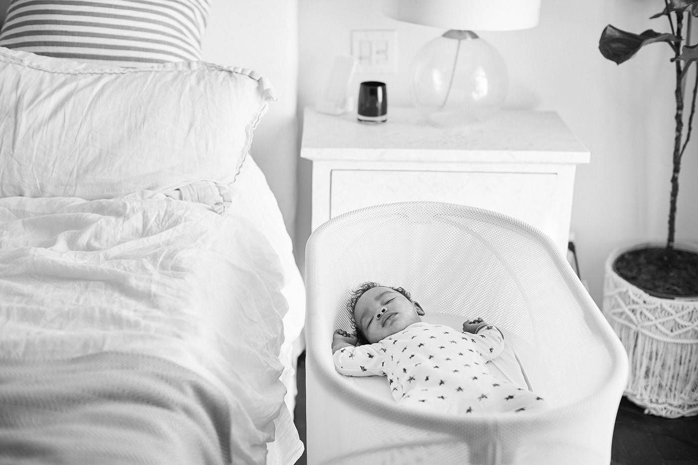 three-month-old-baby-asleep-in-his-cot-beside-the-bed-in-his